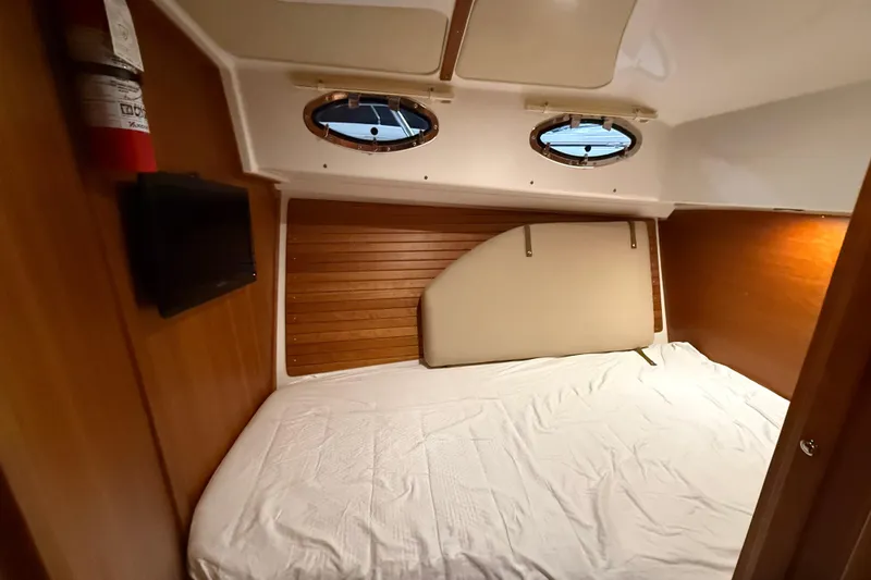 Slide: The Image of 2017 Back Cove 37 cabin interior with bed, portholes, and wooden paneling. - 40