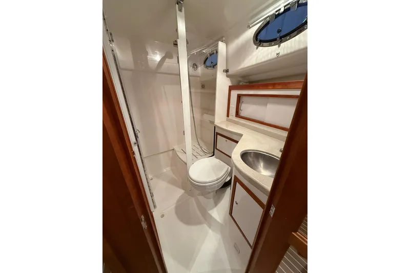 Slide: The Image of 2017 Back Cove 37 yacht bathroom with shower, sink, and porthole window. - 42