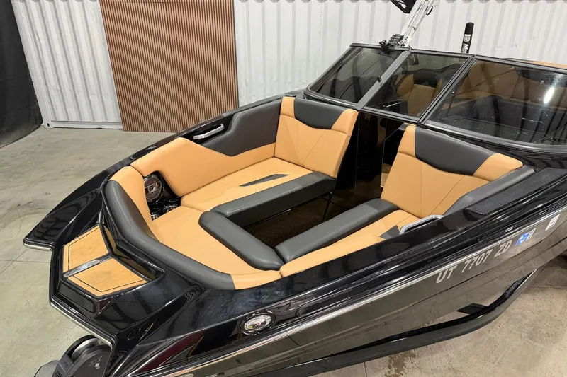 Slide: The Image of 2022 MasterCraft NXT24 boat with tan and black interior, docked indoors. - 3