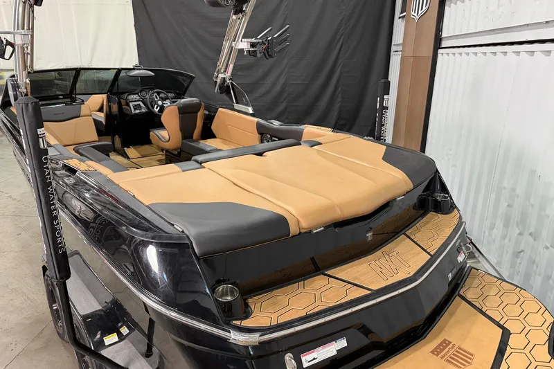 Slide: The Image of 2022 MasterCraft NXT24 boat interior with tan and black seating, showcased indoors. - 4