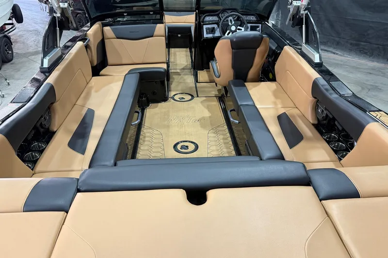 Slide: The Image of 2022 MasterCraft NXT24 boat interior with tan and black seating, modern dashboard, and spacious layout. - 5
