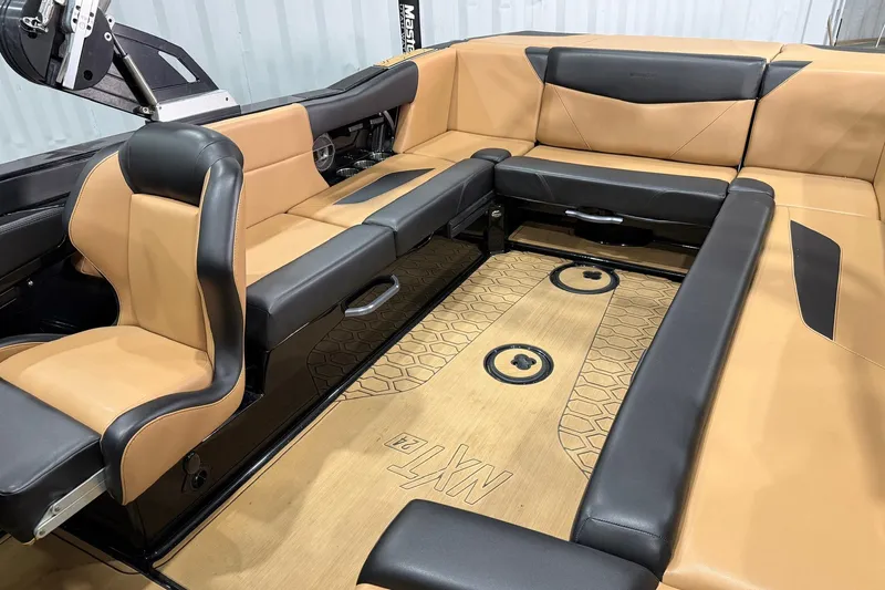 Slide: The Image of 2022 MasterCraft NXT24 boat interior with tan and black seating, spacious layout. - 8