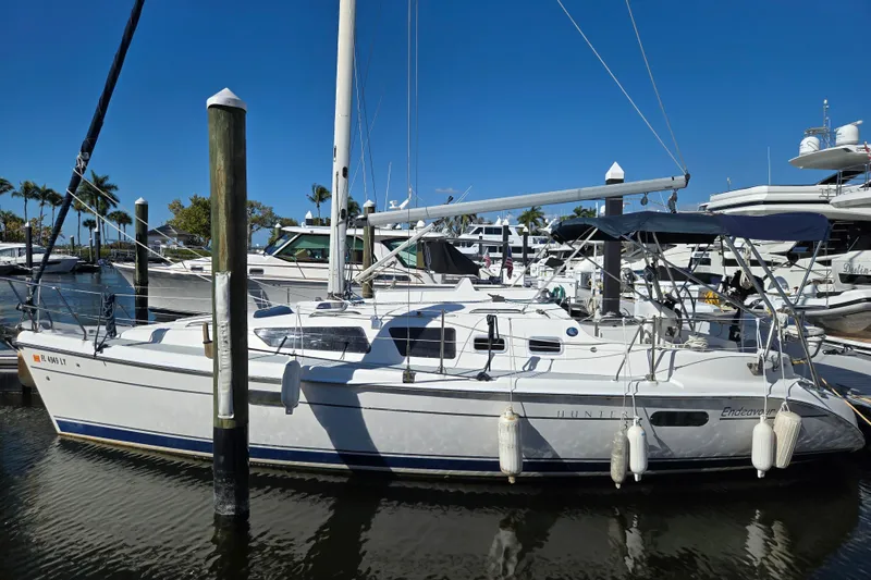 The Image of 2003 Hunter 326 sailboat docked at marina under clear blue sky. - 1