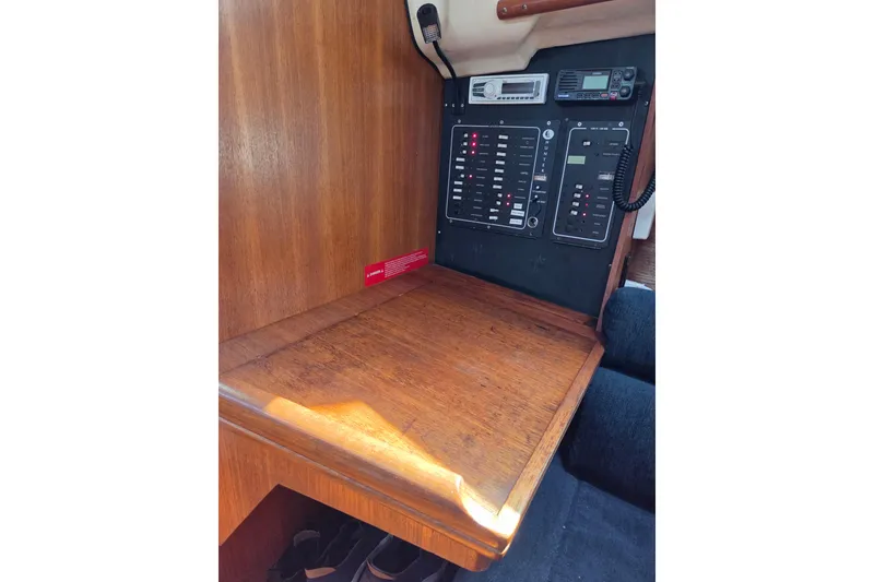 Slide: The Image of 2003 Hunter 326 sailboat interior with navigation panel and wooden desk. - 11
