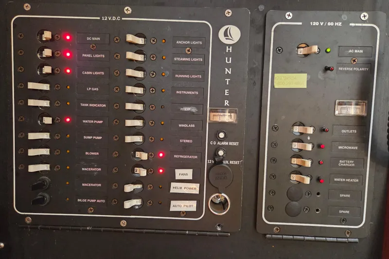 Slide: The Image of Electrical control panel of a 2003 Hunter 326 boat with labeled switches and indicators. - 12
