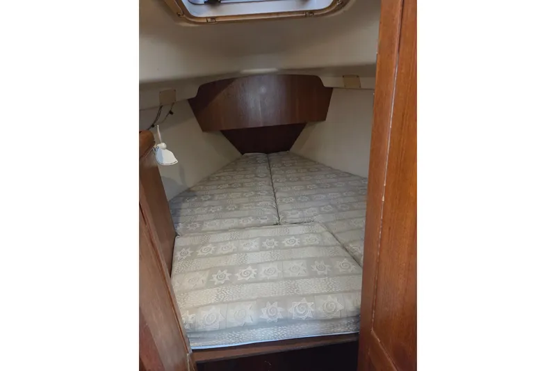 Slide: The Image of Cozy cabin interior of 2003 Hunter 326 sailboat with patterned bedding. - 14
