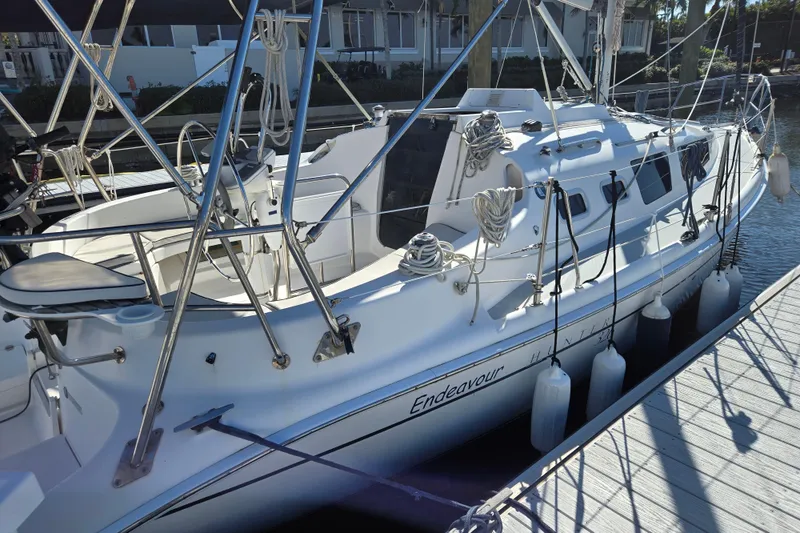Slide: The Image of 2003 Hunter 326 sailboat docked, featuring sleek design and rigging details. - 3