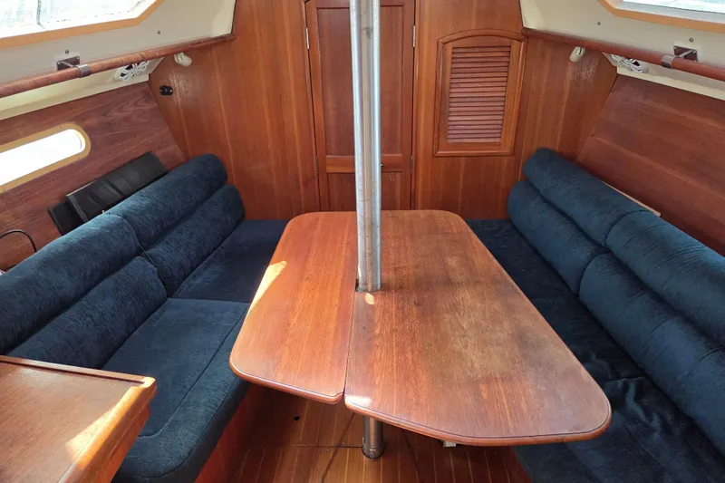 Slide: The Image of Interior of 2003 Hunter 326 sailboat with wooden table and blue seating. - 9