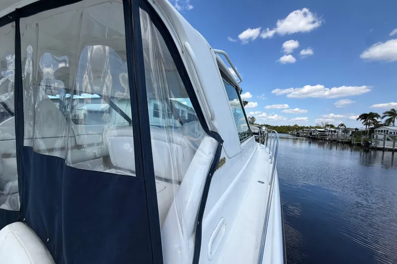 Slide: The Image of 2004 Tiara Yachts 3600 Sovran docked by a serene waterfront under a blue sky. - 10