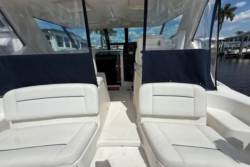 Slide: The Image of 2004 Tiara Yachts 3600 Sovran cockpit with white seating and clear enclosure. - 12