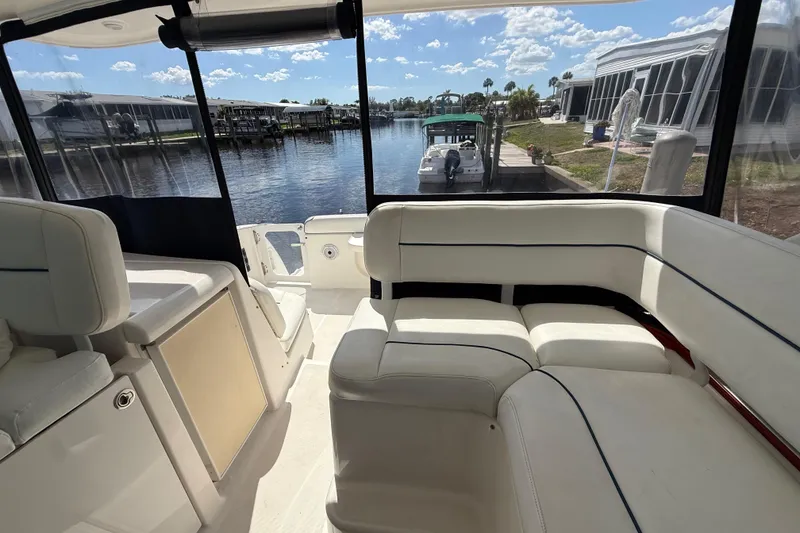Slide: The Image of 2004 Tiara Yachts 3600 Sovran interior with white seating, overlooking marina and waterfront homes. - 25