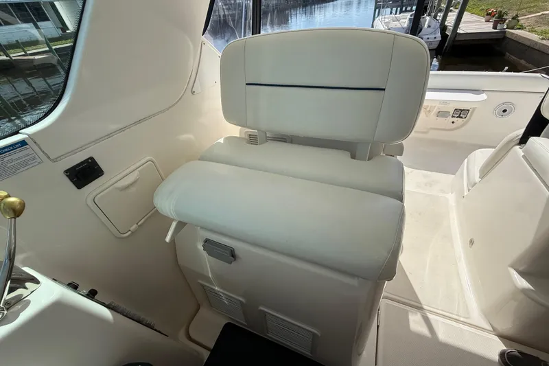 Slide: The Image of Captain's seat on a 2004 Tiara Yachts 3600 Sovran, featuring white upholstery and helm controls. - 28