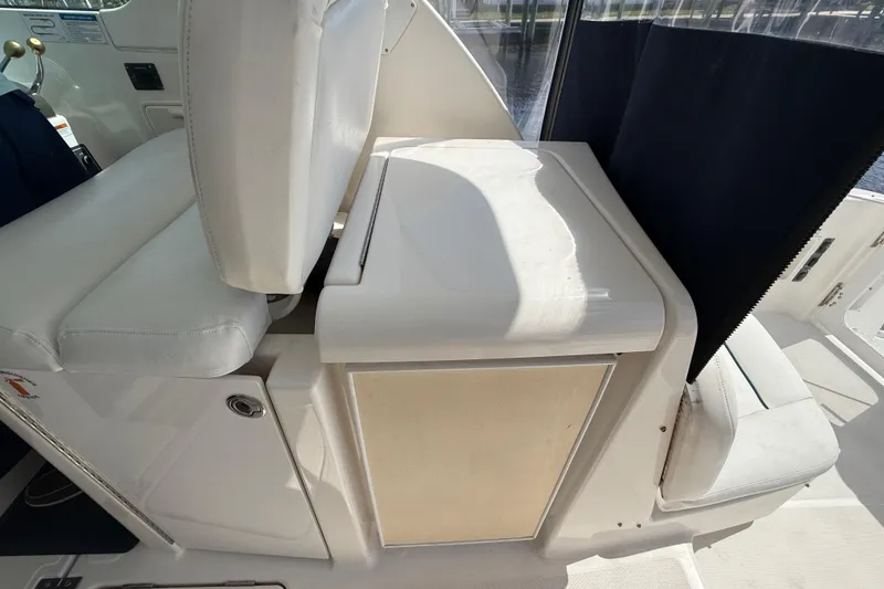 Slide: The Image of 2004 Tiara Yachts 3600 Sovran cockpit seating with white upholstery and storage compartment. - 29