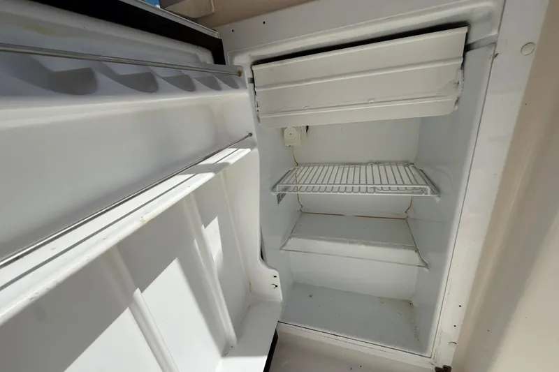 Slide: The Image of Empty refrigerator inside 2004 Tiara Yachts 3600 Sovran, showing shelves and ice compartment. - 31