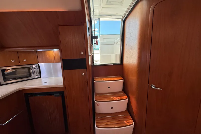 Slide: The Image of Interior of 2004 Tiara Yachts 3600 Sovran with wooden cabinetry and compact kitchen. - 36