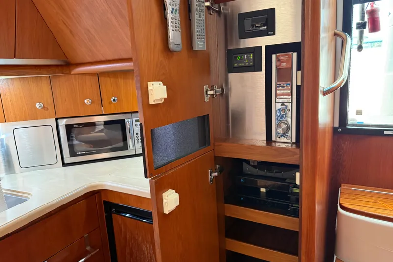 Slide: The Image of 2004 Tiara Yachts 3600 Sovran interior with microwave and control panel in wooden cabinetry. - 37
