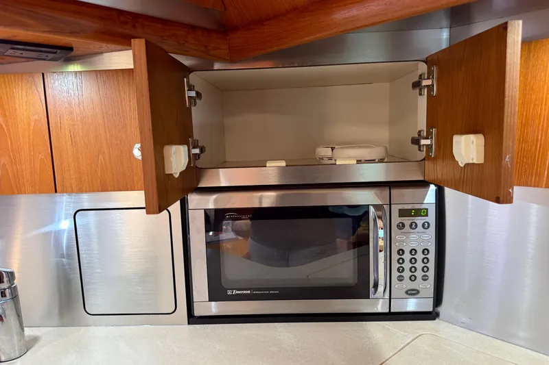 Slide: The Image of 2004 Tiara Yachts 3600 Sovran galley with microwave and open wooden cabinets. - 41