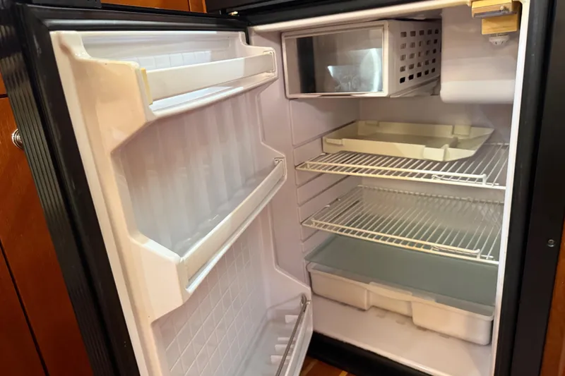 Slide: The Image of Open refrigerator inside a 2004 Tiara Yachts 3600 Sovran, showing empty shelves and compartments. - 43