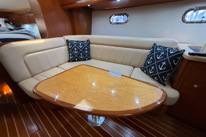 Slide: The Image of 2004 Tiara Yachts 3600 Sovran interior with cozy seating and nautical-themed pillows. - 47