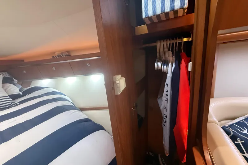 Slide: The Image of Cozy cabin interior of 2004 Tiara Yachts 3600 Sovran with striped bedding and closet space. - 59