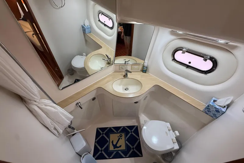 Slide: The Image of Bathroom interior of 2004 Tiara Yachts 3600 Sovran with sink, toilet, and porthole window. - 62