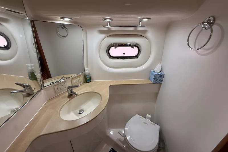 Slide: The Image of Luxurious bathroom in 2004 Tiara Yachts 3600 Sovran with sink, mirror, and porthole window. - 63