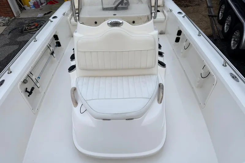 Slide: The Image of 2007 Mako 2201 Tunnel Inshore boat interior with white seating and storage compartments. - 10