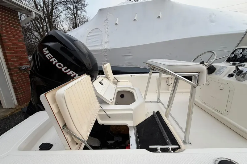 Slide: The Image of 2007 Mako 2201 Tunnel Inshore boat with Mercury engine, featuring seating and control panel. - 12
