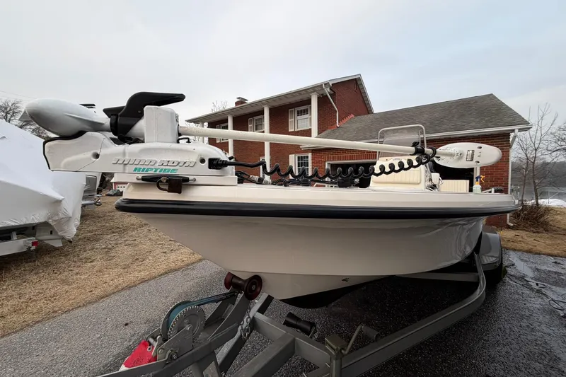 Slide: The Image of 2007 Mako 2201 Tunnel Inshore boat on trailer, parked near a brick house. - 4
