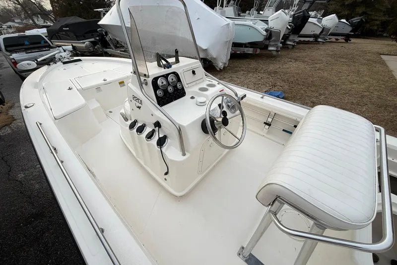 Slide: The Image of 2007 Mako 2201 Tunnel Inshore boat with steering console and seating, parked outdoors. - 5
