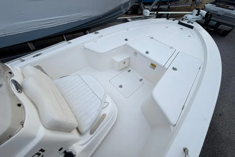 Slide: The Image of 2007 Mako 2201 Tunnel Inshore boat interior with white seating and storage compartments. - 9