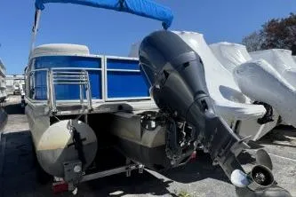 Slide: The Image of 2021 Godfrey Sweetwater 2286 C pontoon boat with outboard motor, blue canopy, docked outdoors. - 4