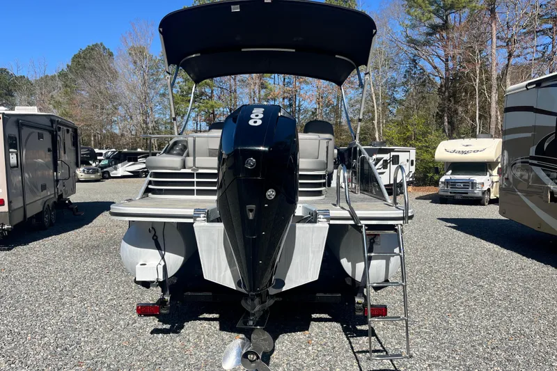 The Image of 2022 Bennington 23LT pontoon boat with outboard motor in a parking lot. - 1