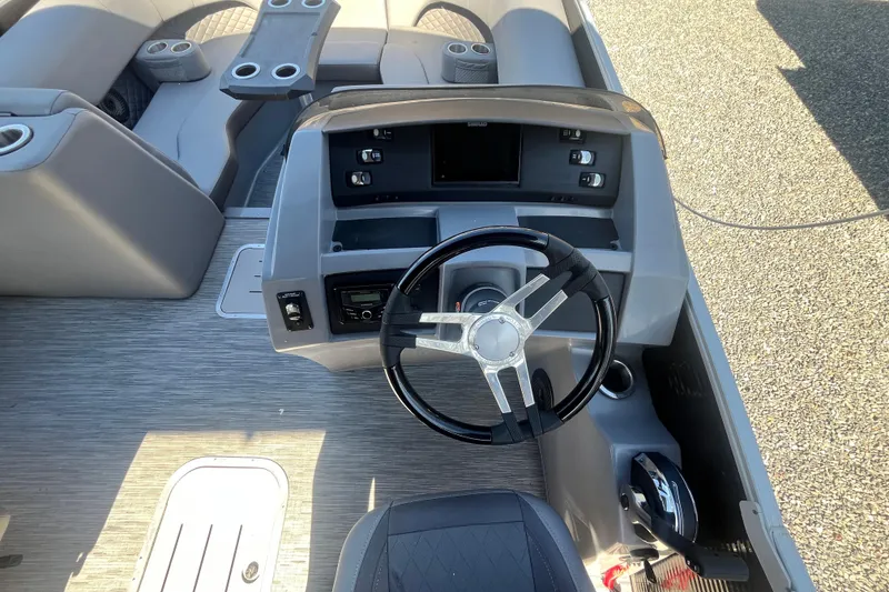 Slide: The Image of 2022 Bennington 23LT boat interior with steering wheel and seating area. - 7