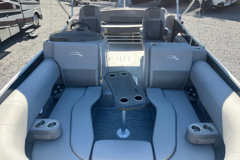 Slide: The Image of 2022 Bennington 23LT boat interior with gray seating and cup holders. - 9