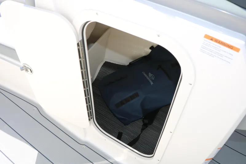Slide: The Image of Storage compartment on 2026 Chaparral 23 SSi boat with a blue bag inside. - 36
