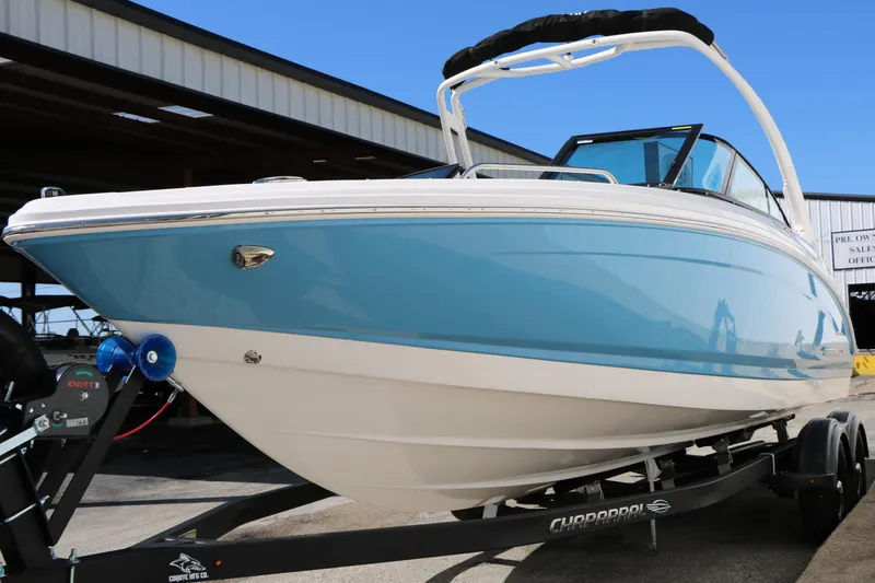 Slide: The Image of 2026 Chaparral 23 SSi boat on trailer, blue and white exterior, parked outdoors. - 4
