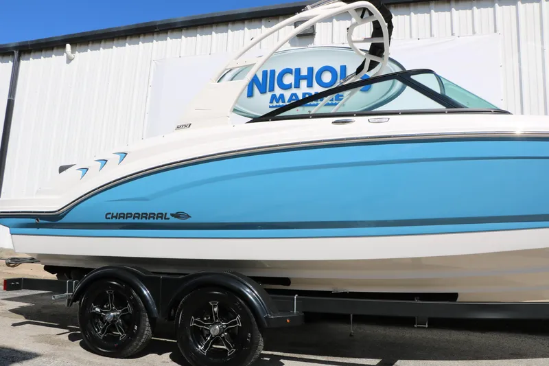 Slide: The Image of 2026 Chaparral 23 SSi boat in blue and white on trailer at dealership. - 6