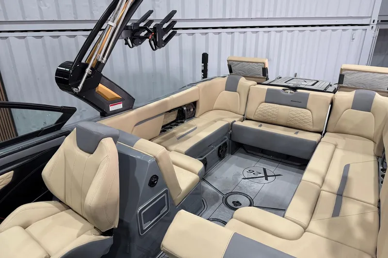 Slide: The Image of 2022 MasterCraft X26 boat interior with beige and gray seating, showcasing luxury and comfort. - 10