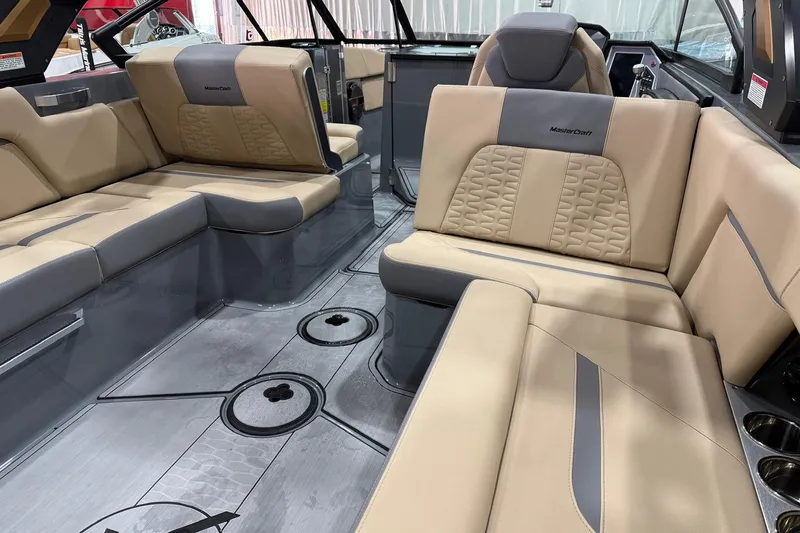 Slide: The Image of 2022 MasterCraft X26 boat interior with beige and gray seating, showcasing luxury design. - 11