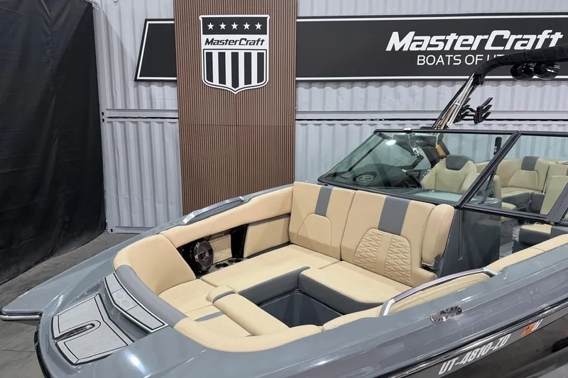 Slide: The Image of 2022 MasterCraft X26 boat interior with beige seating, displayed at a showroom. - 6