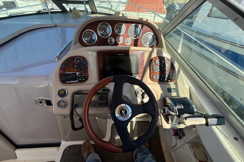 Slide: The Image of Cockpit of 2003 Sea Ray 300 Sundancer with steering wheel and control panel. - 10