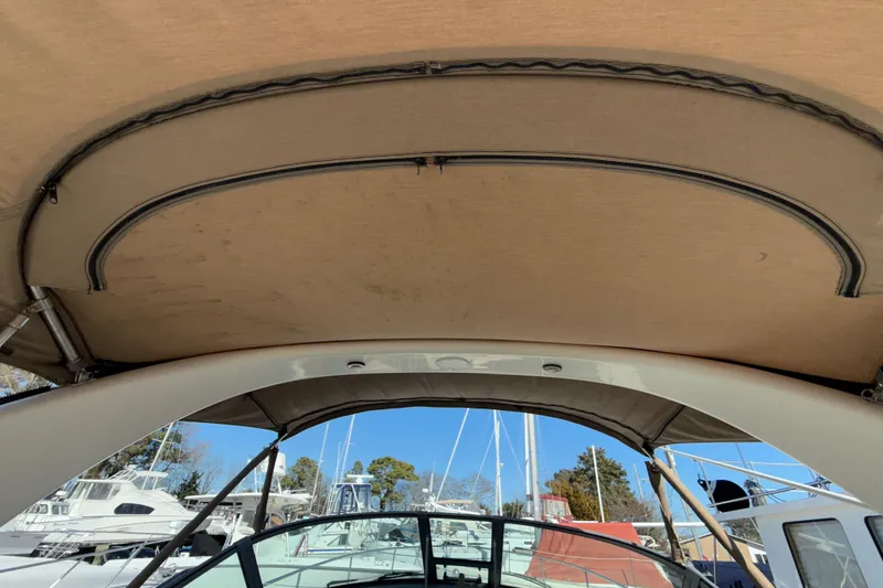 Slide: The Image of 2003 Sea Ray 300 Sundancer boat canopy with marina background. - 13