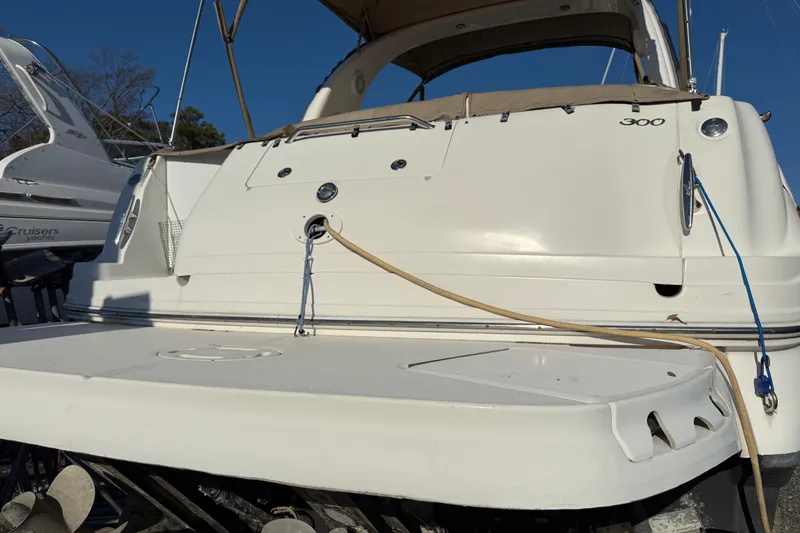 Slide: The Image of 2003 Sea Ray 300 Sundancer boat docked, rear view with swim platform. - 2