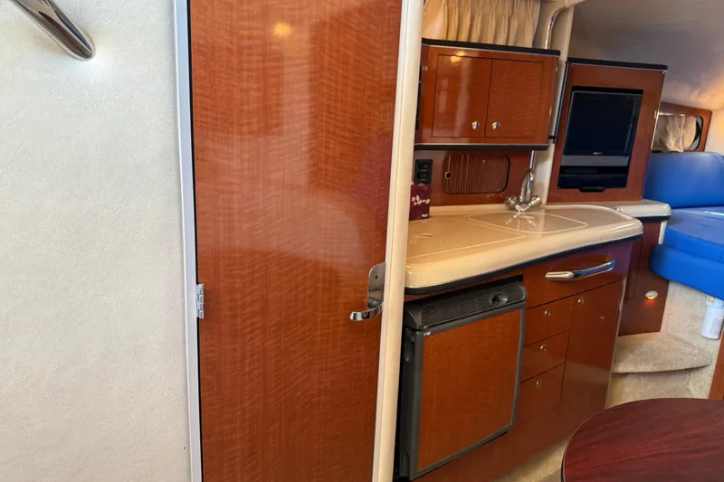 Slide: The Image of Interior of 2003 Sea Ray 300 Sundancer with kitchenette and seating area. - 23