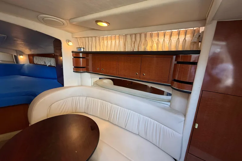 Slide: The Image of 2003 Sea Ray 300 Sundancer interior with elegant wood cabinetry and plush seating. - 25