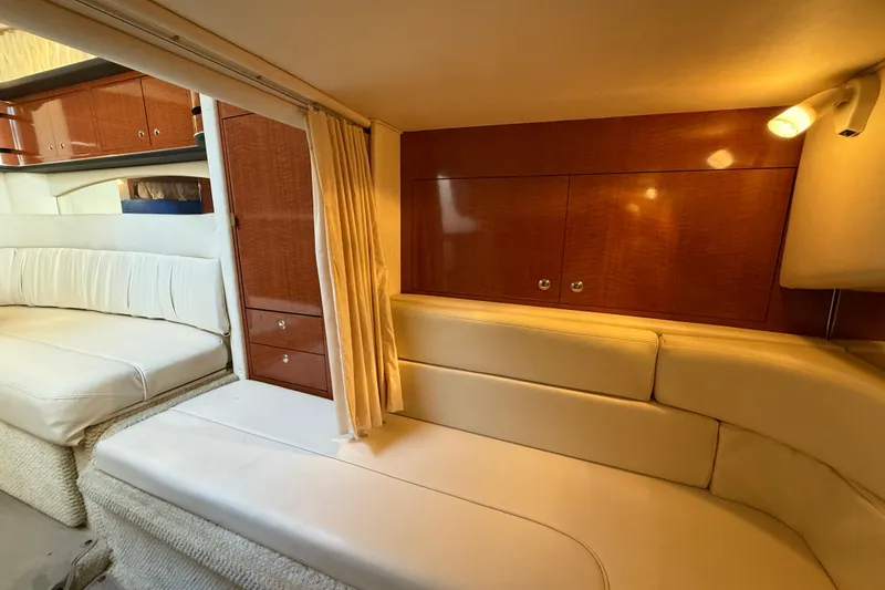 Slide: The Image of Interior of 2003 Sea Ray 300 Sundancer with cream seating and wooden cabinetry. - 26