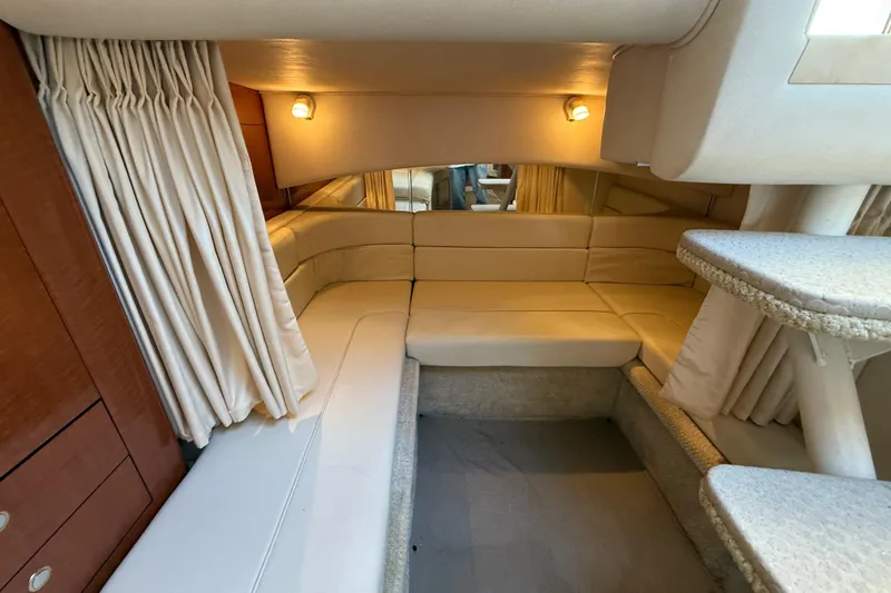 Slide: The Image of Interior of 2003 Sea Ray 300 Sundancer yacht with beige seating and curtains. - 29