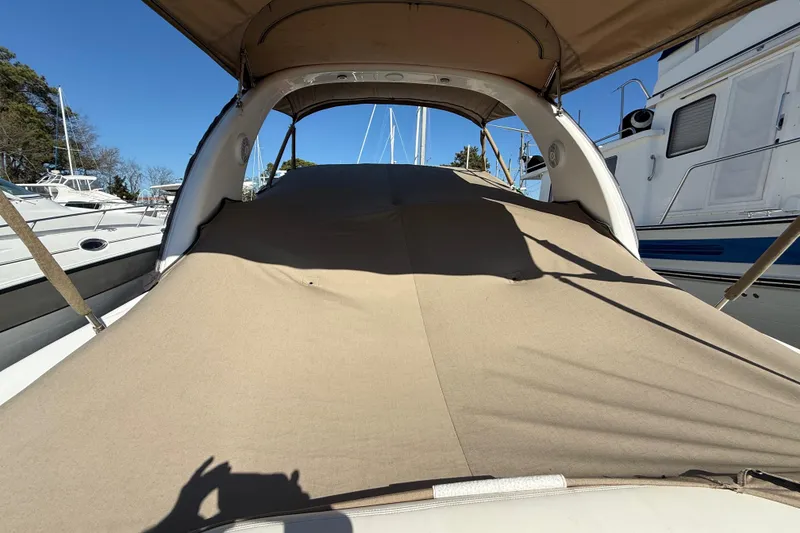 Slide: The Image of 2003 Sea Ray 300 Sundancer with protective cover in marina setting. - 3