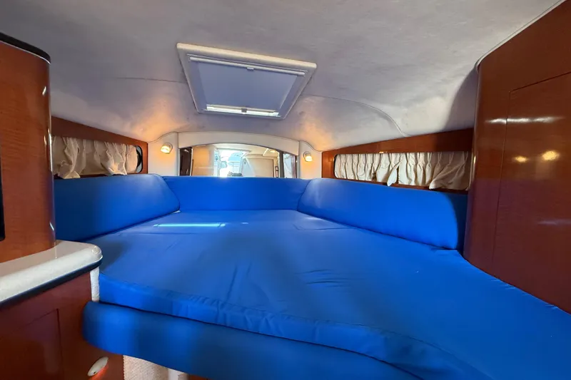 Slide: The Image of Interior cabin of 2003 Sea Ray 300 Sundancer with blue upholstery and wood accents. - 33